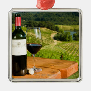 Bottle of red wine and glass on table metal tree decoration