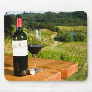 Bottle of red wine and glass on table mouse pad