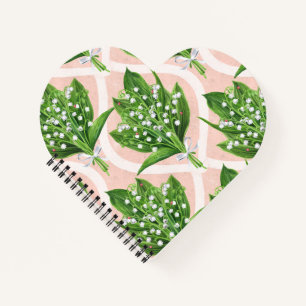 Bouquet of lilly of the valley flowers on pink notebook