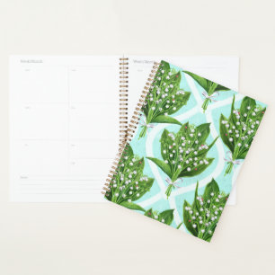 Bouquet of lily of the valley flowers on blue planner
