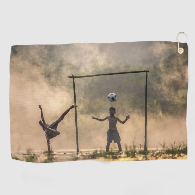 Boy kicking a football in the water Towels (Horizontal)