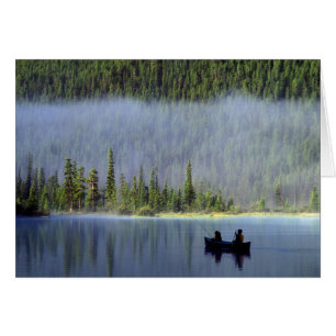Boys fishing from canoe with mist in