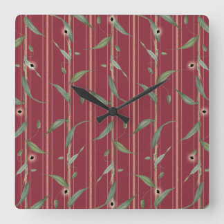 Branch of leaves on red wallpaper square wall clock