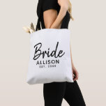 Bride Script White Black Established Date Monogram Tote Bag<br><div class="desc">You can not go without this Bride Script White Black Established Date Monogram Tote Bag. It is designed on both sides with "bride" in modern black script lettering. Personalised with bride's name and established year of wedding. Great gift idea for bridal shower, bachelorette party and honeymoon. CLICK PERSONALIZE TEMPLATE OPTION...</div>