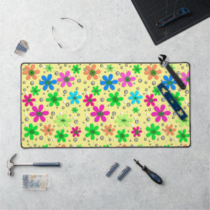 Bright multi-coloured chamomile flowers on a yello desk mat