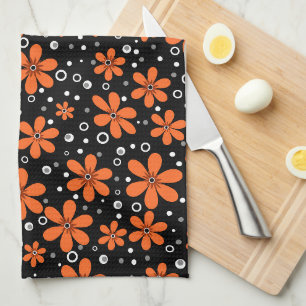 Bright orange flowers on a black background with w tea towel