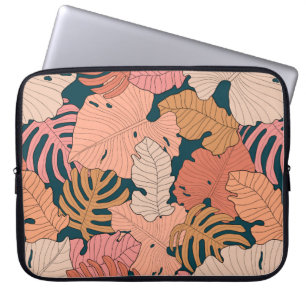 Bright pink, orange, yellow leaves of monstera and laptop sleeve