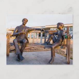 Bronze statue of young and older talking holiday postcard