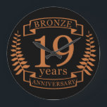 Bronze traditional wedding anniversary 19 years large clock<br><div class="desc">A design to celebrate 19 years of marriage. This design has a bronze colored laurel design on a black background. Bronze is the traditional gift for this occasion. The text reads bronze 19 years anniversary. A romantic design to celebrate your 19th year of marriage. If you would like any help...</div>