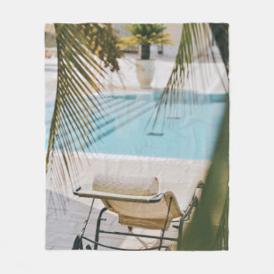 Brown and black armchair beside swimming pool in t fleece blanket