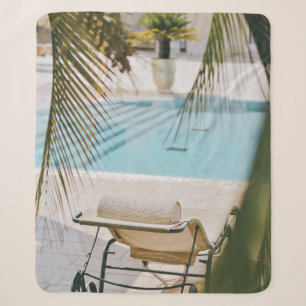 Brown and black armchair beside swimming pool in t sherpa blanket
