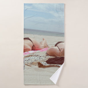 Brown glass bottle across two women bath towel