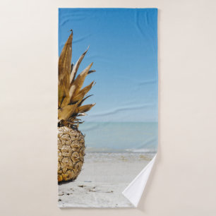 Brown pineapple fruit on seashore bath towel