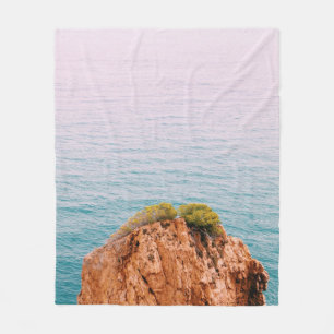 Brown rock mountain on body of water fleece blanket