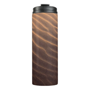 Brown sand with water in the morning thermal tumbler