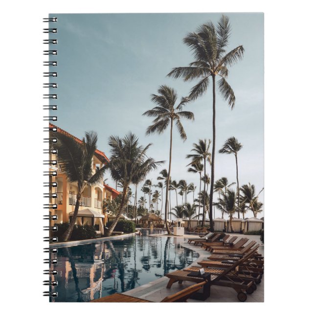 Brown wooden lounge chairs near pool surrounded by notebook (Front)