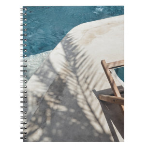 Brown wooden lounger near body of water notebook