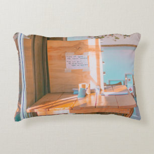 BROWN WOODEN TABLE WITH WHITE PRINTER PAPER DECORATIVE CUSHION