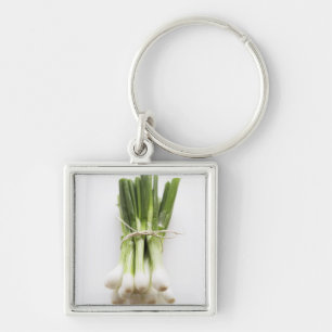 Bunch of spring onions on white chopping board key ring