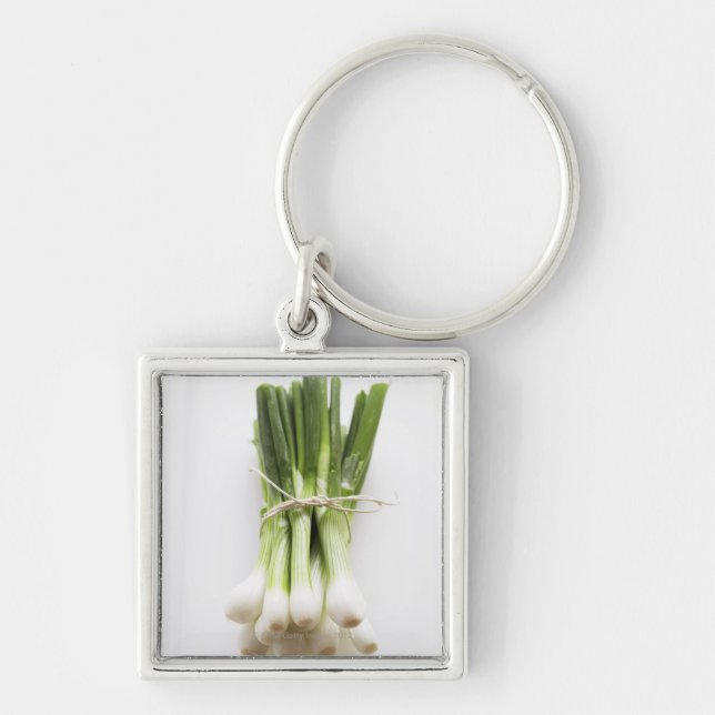 Bunch of spring onions on white chopping board key ring (Front)