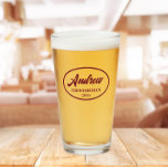 Burgundy Stylised Wedding Groomsman Name Glass<br><div class="desc">Beer glass for the wedding groomsman that features his name printed in burgundy,  stylised script inside a burgundy colour oval border along with wedding date. A great party supply idea for a bachelor party!Personalise your beer glass by editing and replacing name and date with your own.</div>