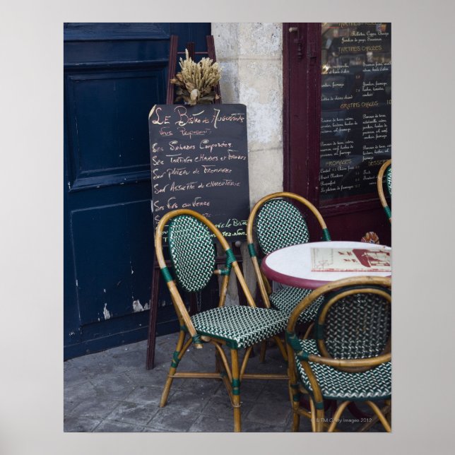 Cafe table with cane chairs in Paris, France Poster (Front)