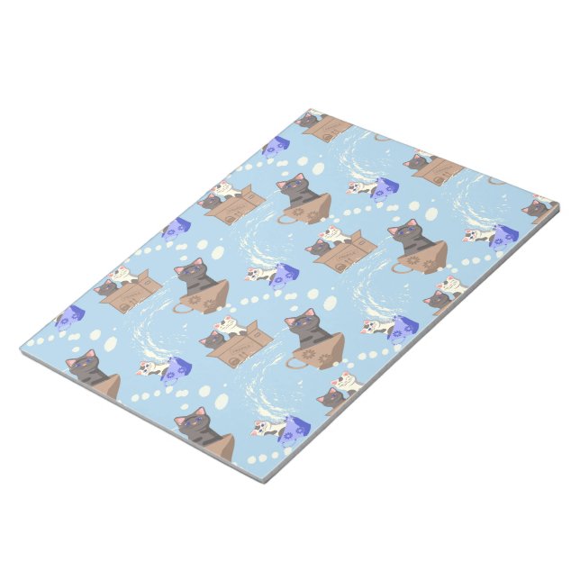 Cats in box and milk drops on blue notepad (Angled)