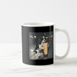 Cavalier king charles spaniel drinking iced coffee mug