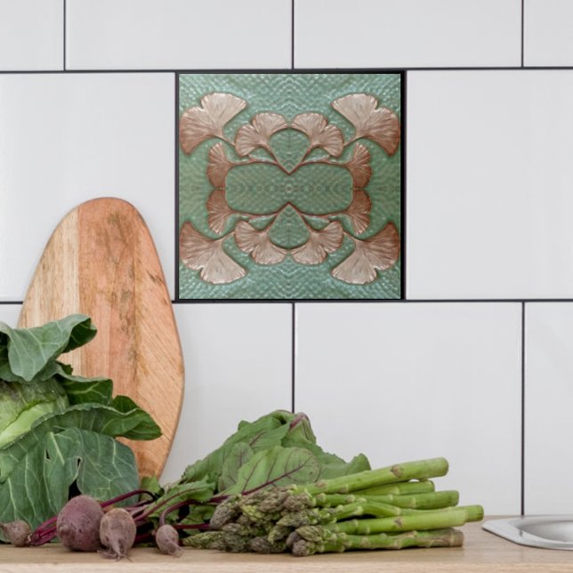 Ceramic Gingko Tile (Single Green and copper Gingko leaf tile shown with white tiles in a kitchen.)