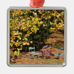 Chairs among fall leaves metal ornament
