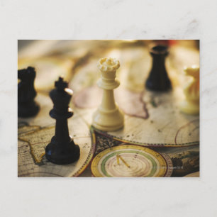 Chess pieces on old world map postcard