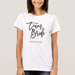 Chic Trendy Brush Black Script Team Bride T-Shirt<br><div class="desc">T-shirt featuring the words "Team Bride" in chic trendy brush black script that's perfect for bridesmaids, maid of honour and flower girl. For other matching items see here https://www.zazzle.com/collections/119250194970828530?rf=238364477188679314 Personalise it by replacing the placeholder text. For more options such as to change the font and it's size, colour or the...</div>