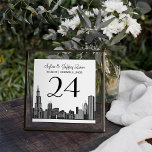 Chicago Skyline Wedding Table Number Card<br><div class="desc">The iconic Chicago skyline silhouette stretches across this sophisticated wedding table number card, perfect for couples celebrating in the Windy City. The couple's names, wedding date, and city location are displayed in elegant calligraphy and serif typography for a personalised monogram design. The couple's names, date, location, and table number are...</div>