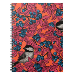 Chickadee birds on blueberry branches on orange notebook