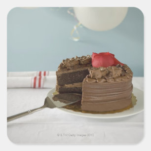 Chocolate cake with missing slice on table, square sticker