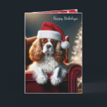 Christmas King Charles Spaniel On a Red Chair Holiday Card<br><div class="desc">A King Charles spaniel dog wearing a Santa hat sits on a red chair next to a glowing Christmas tree adorned with shiny ornaments.
All text can be changed.</div>
