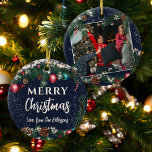 Christmas lights pine branches snow blue photo ceramic ornament<br><div class="desc">Celebrate your holiday memories with this charming round Christmas tree ornament. Featuring a festive green pine garland with sparkling lights, pine cones, and red and blue baubles, this ornament allows for customisation with your family's name on the front and a cherished photo on the back. Perfect for adding a personalised...</div>