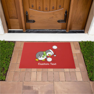 Christmas penguin getting a snow ball doormat