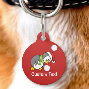 Christmas penguin getting a snow ball pet tag