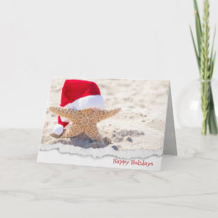 Christmas Santa hat on starfish in sand Holiday Card