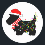 Christmas Scottie Dog With Lights Classic Round Sticker<br><div class="desc">Scottish Terrier dog lovers will enjoy this festive,  black Scottie Dog wearing a Santa hat,  red and white striped scarf and colourful string lights!  Get into the Christmas spirit with this funny design on customisable gifts!</div>