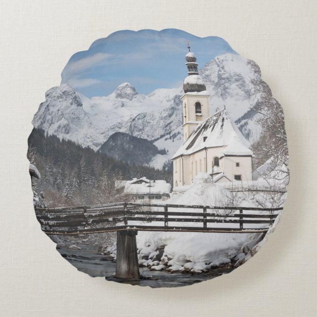 Church in the snow with Alps mountains in winter Round Cushion (Front)