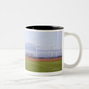 Clean energy by many wind turbines on fields. Two-Tone coffee mug