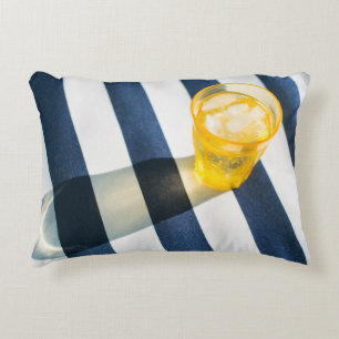Clear drinking glass with yellow liquid decorative cushion