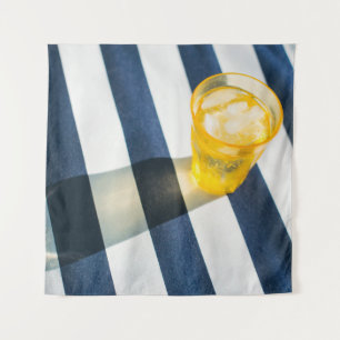 Clear drinking glass with yellow liquid tapestry
