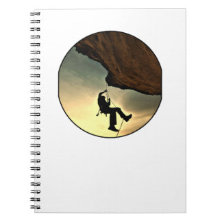 Climbing mountain man at sunset notebook