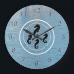 Clock - Seahorses, Water and White Rings<br><div class="desc">White porthole suggested by wavy circle within a solid circle, encircles four black seahorses in center, one large at top and three smaller beneath. Numerals have a three dimensional look in silver. Background of blue harbor water.</div>