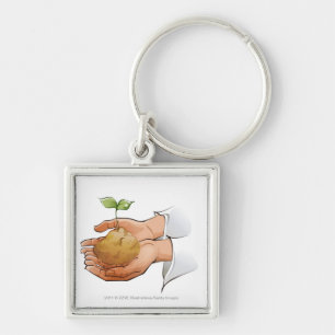 Close-up of a person's hands holding seedling key ring