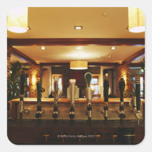 Close-up of beer taps in bar square sticker