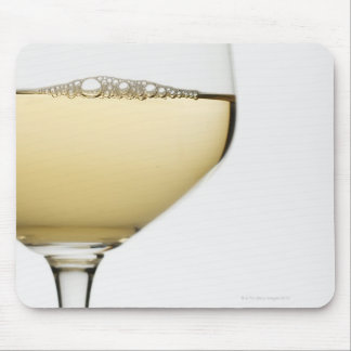 Close up of glass of white wine on white mouse pad
